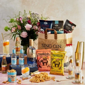 A group of bottles of alcohol and flowers on a table with a bag