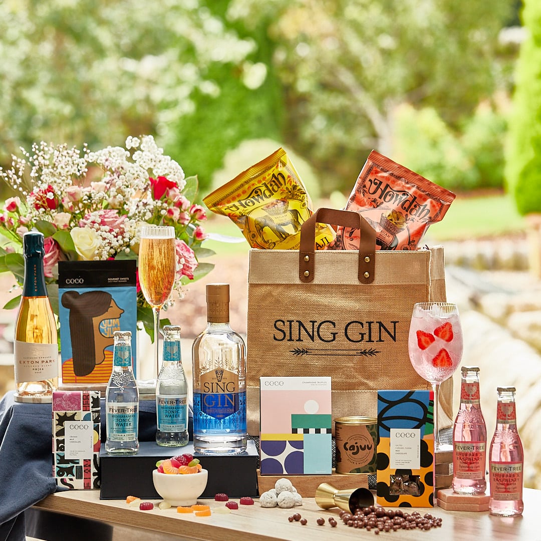 Luxury hamper containing a range of foods, a large bottle of gin and sparkling wine